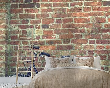 Grootmoeder fiets  staat tegen een oude bakstenen muur