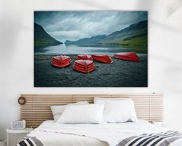 Rote Boote an einem einsamen schwarzen Strand auf den Färöer Inseln