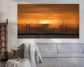 Zon gaat onder boven de Oosterschelde kering met schitterende gouden rand langs de wolken van Gert van Santen