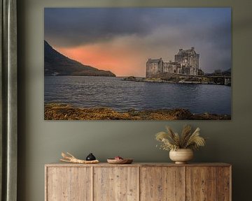 Stimmungsvolles Foto von Eilean Donan Castle während eines farbenprächtigen Sonnenuntergangs. Dramatisches Licht, raues Wasser und schottische Natur als zeitloser Wandschmuck.