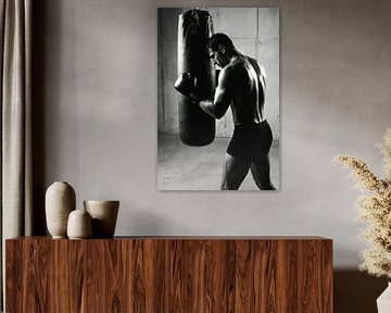 Mann mit Boxhandschuhen, der auf einen Boxsack schlägt, schwarz und weiß