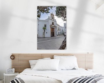 Kerk in een witte huisgevel, Iglesia de San Roque in Rota, Cadiz, Andalusië, Spanje. van Fotos by Jan Wehnert
