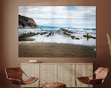 Coastal Beach With Rocky Outcrops and Cliffside Shoreline Under Cloudy Sky