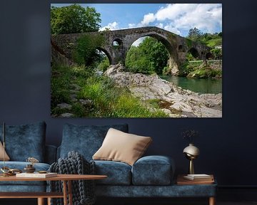 Stenen brug over een rustige rivier omgeven door weelderig groen in spanje van ChrisWillemsen