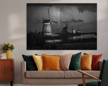 Blitze an den beleuchteten Windmühlen von Kinderdijk, Niederlande. Schwarz-Weiß-Foto.