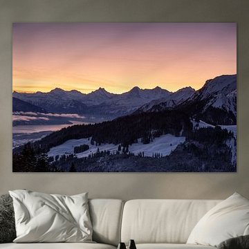 Uitzicht op de beroemde besneeuwde bergen van de Schreckhorn, Eiger en het meer van Thun bij zonsopgang in de winter