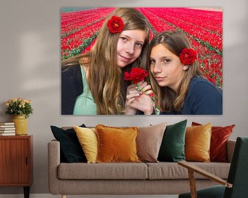 Two girls with red roses in front of tulip field sur Ben Schonewille