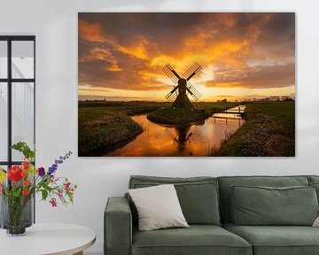 Molen Terpzigt weerspiegeld in het water tijdens een kleurrijke zonsondergang