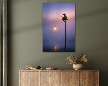 Fischer mit Licht über ruhigem Wasser