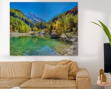 Herbstfarben und ein schneebedeckter Berg spiegeln sich in einem kleinen See im Tal Anniviers, Zinal