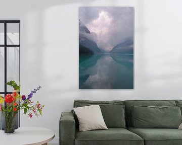 Serene dark lake with reflection of majestic mountains in a misty setting