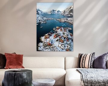 Traditional red rorbuer with snow in lofoten fjord village by Markus Gann