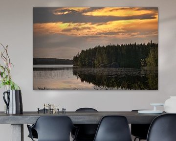 Gouden zonsondergang boven een rustig bosmeer in Scandinavië.