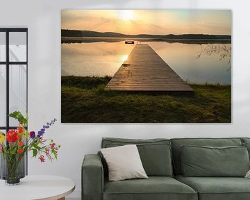 A wooden jetty on the lake in the morning mist, flooded with sunlight and a calm reflection. by Martin Köbsch