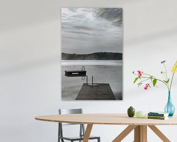 A wooden jetty on the lake in the morning mist, flooded with sunlight and a calm reflection. by Martin Köbsch
