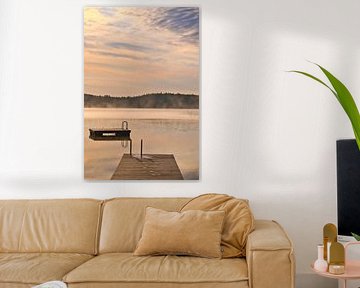 A wooden jetty on the lake in the morning mist, flooded with sunlight and a calm reflection. by Martin Köbsch