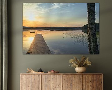 A wooden jetty on the lake in the morning mist, flooded with sunlight and a calm reflection. by Martin Köbsch