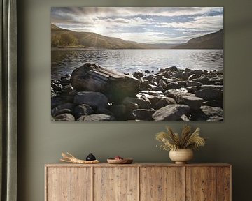 Rustig bergmeer met herfstheuvels en rotsen in het heldere water