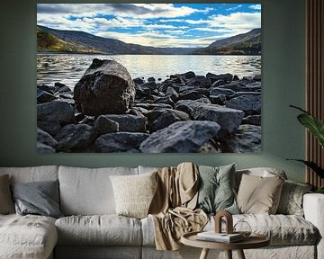 Rustig bergmeer met herfstheuvels en rotsen in het heldere water