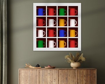 Sechzehn farbige Tassen in einem Regal von Jörg Hausmann