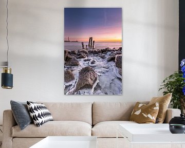 Gefrorene Pfähle im IJsselmeer bei einem farbenprächtigen Sonnenaufgang im Winter von Bram Lubbers