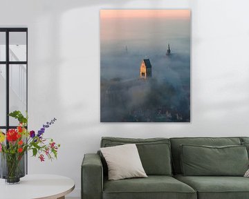 Churches of Bolsward above the fog at sunrise by Ewold Kooistra