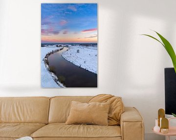 Vecht river flowing through a snowy winter landscape during suns
