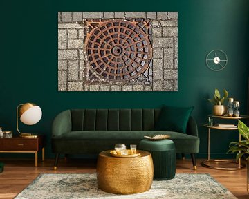 Cast iron manhole cover in paving by MMFoto