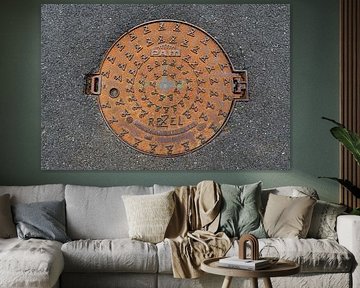 Runder Gusseisen-Schachtdeckel in Asphalt von MMFoto