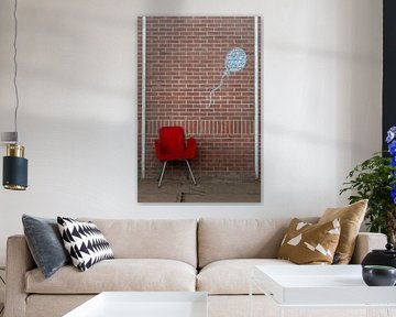 Roter Stuhl vor Backsteinmauer