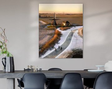 Skating near a windmill in a winter landscape von Ewold Kooistra