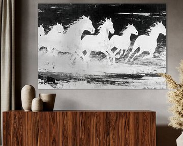 Weiße Pferde laufen an der Küste entlang