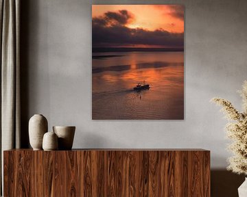 Ein Fischerboot fährt ruhig über das spiegelglatte Wasser. von Ewold Kooistra