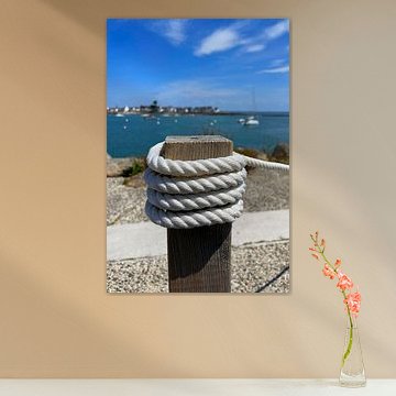 White rope tied around a wooden post at the harbour by Theodor Decker