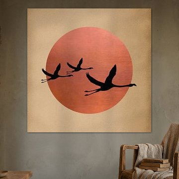 Silhouetten fliegender Kraniche vor einer rot-kupferfarbenen Sonne