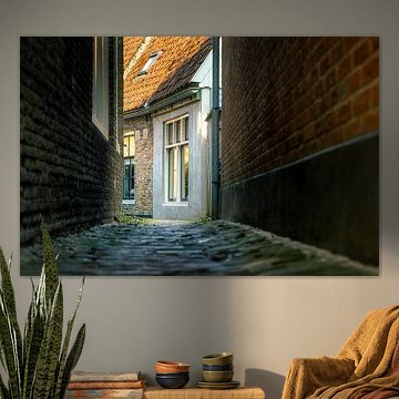 Eine Gasse im Abendlicht mit Kopfsteinpflaster und Backsteinmauern