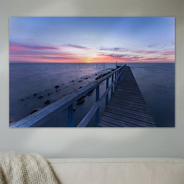 Ein Holzsteg, der ins Markermeer hinausführt, bei einem farbenprächtigen Sonnenaufgang in der Nähe von Edam in Nordholland von Bram Lubbers