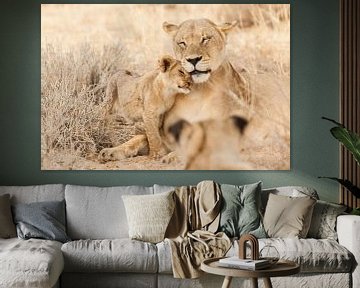 Knuffelende leeuwin met welp in Botswana van Simone Janssen