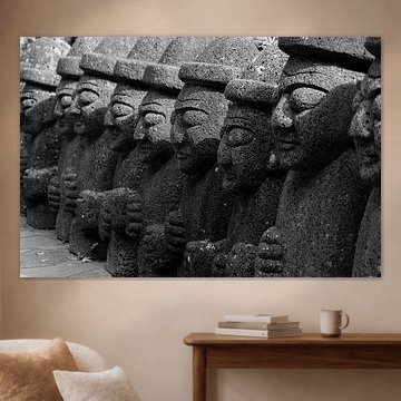 Row of Dol Hareubang in black and white – stone statues carved from volcanic rock on Jeju Island, South Korea by The Book of Wandering