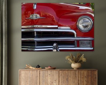 Hood and grill of a red classic car . by martin von rotz