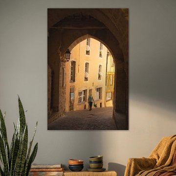 De voorbijganger ( voetganger in een mooi Normandisch stadje door een poort heen gezien)