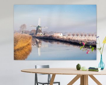 Hollandse molen in winters landschap aan het water van Inge van den Brande