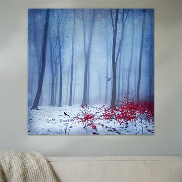 Besneeuwd winterbos met rood herfstblad