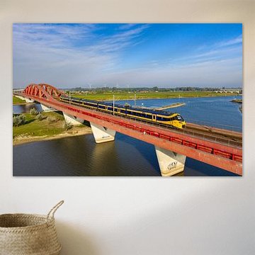 ICNG intercity train driving over a bridge crossing the river IJssel