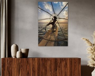 Visser die met traditionele boot op het Inle meer in Myanmar op ouderwetse wijze met een vis korf vi van Wout Kok