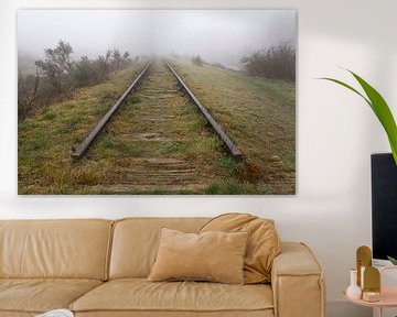 Old railway line shrouded in the fog. by Tonko Oosterink