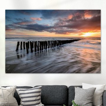 Breakwaters on the beach during sunset by Arnoud van de Weerd