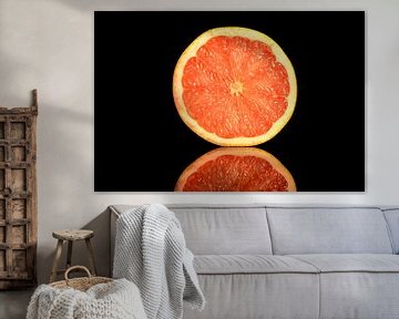 Dwarsdoorsnede een frisse oranje grapefruit op een zwarte achtergrond van Sjoerd van der Wal