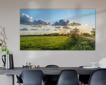 Typisch Nederlands polderlandschap met prachtige wolken en ondergaande zon