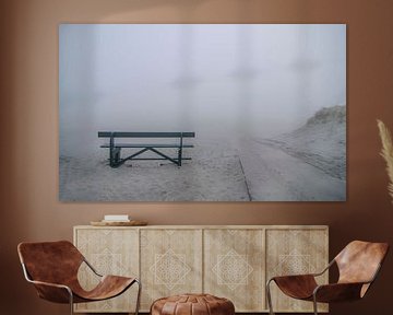 Leaving bench in the fog on the beach of Ameland.